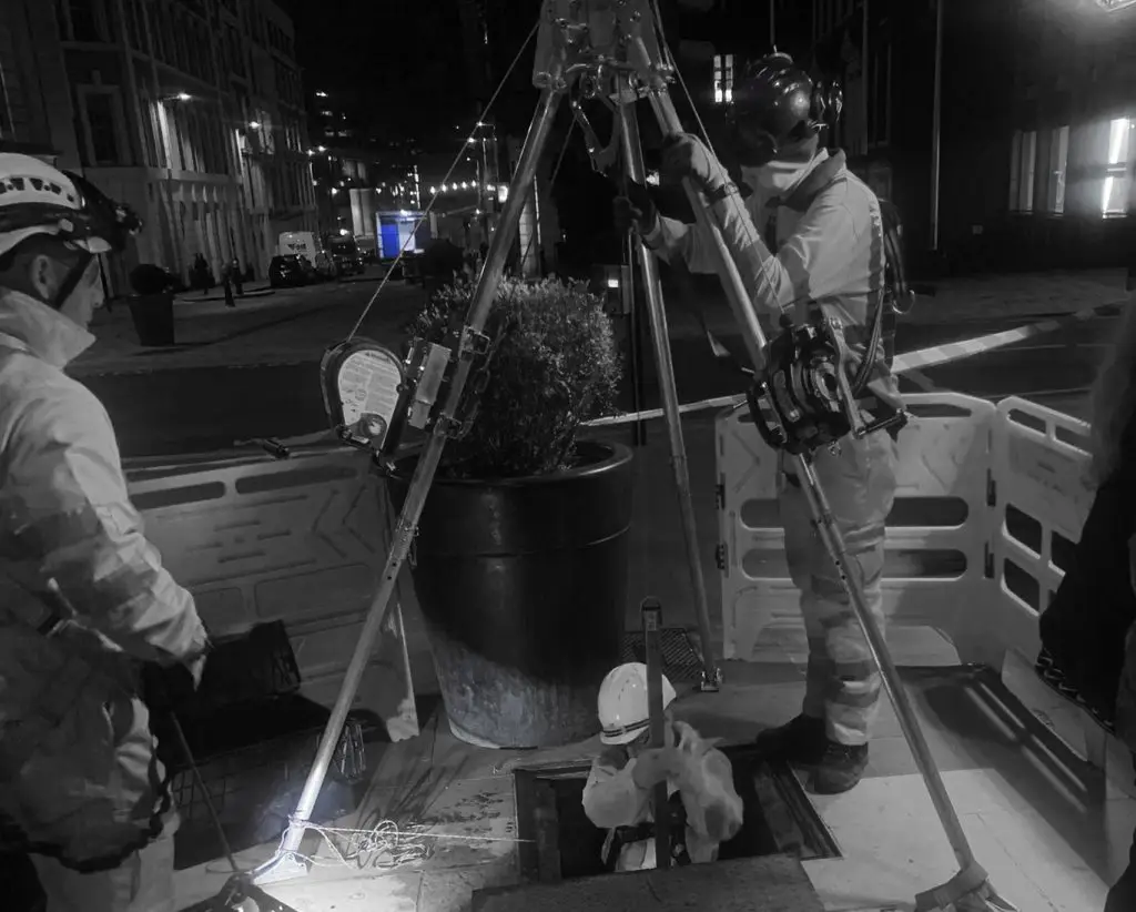 “Certified surveyor using a 3D laser scanner inside a confined space chamber.”