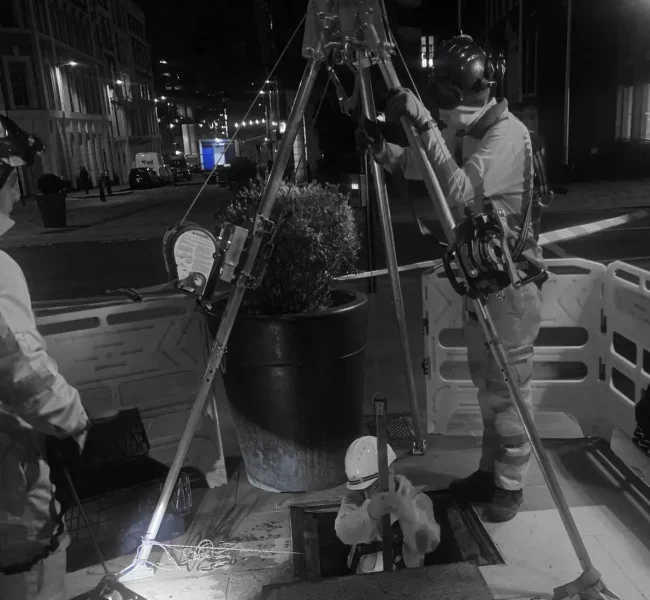 “Certified surveyor using a 3D laser scanner inside a confined space chamber.”